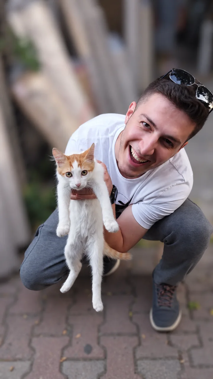 Enes Mut, kucağındaki kediyle gülümserken